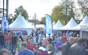 Mad science flag surrounded by people at a fair